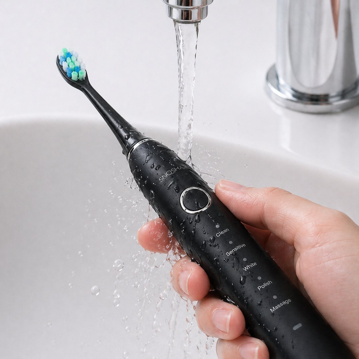 Snosha N2 black electric toothbrush being rinsed under running tap demonstrating IPX7 waterproof