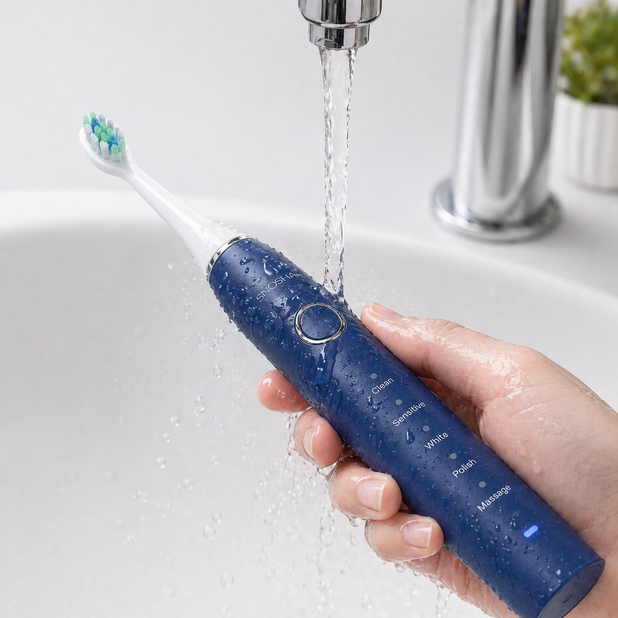 Snosha N2 blue electric toothbrush being rinsed under tap demonstrating IPX7 waterproof