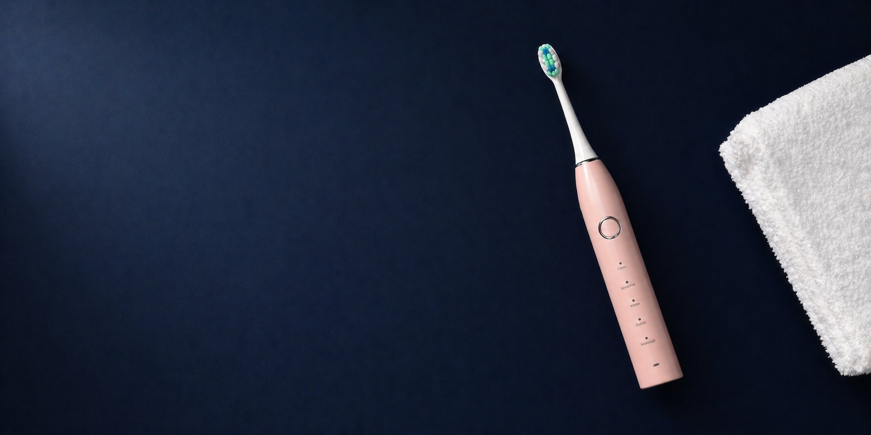 Snosha N2 pink electric toothbrush with oral care accessories on dark navy background